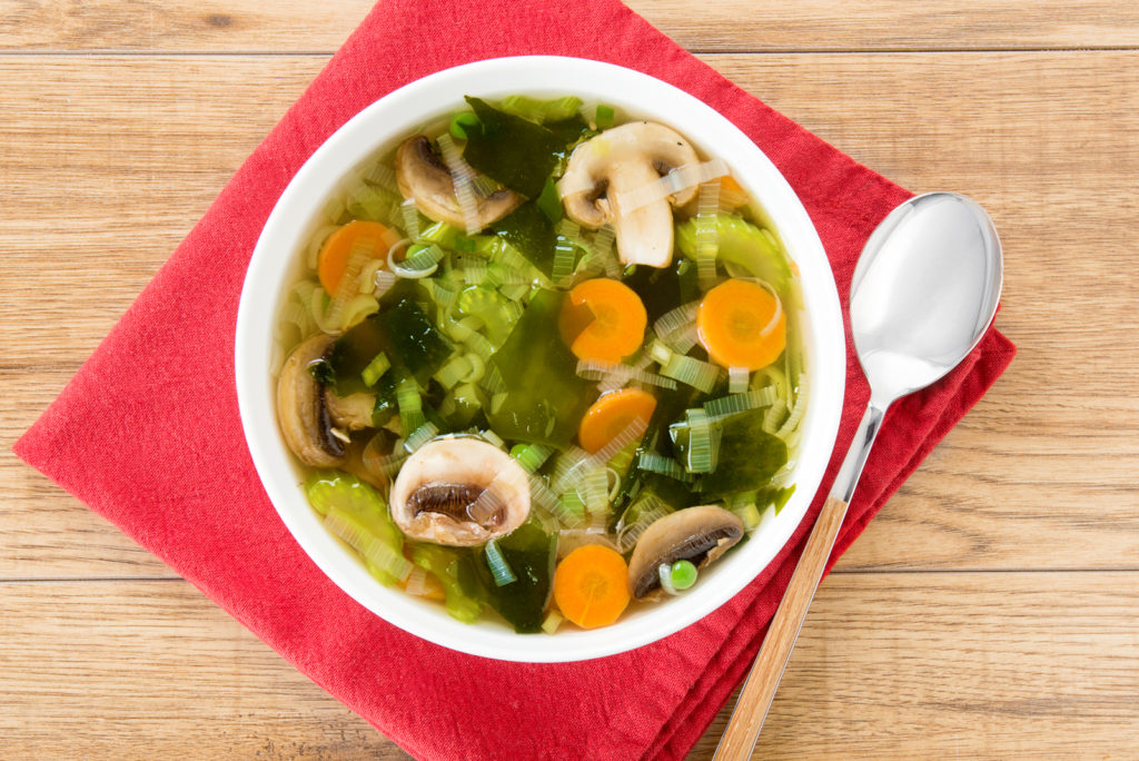 Green Leek and San-J Wakame Soup in a bowl on a serviette with a spoon